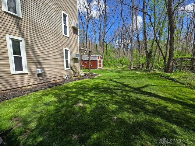 view of yard featuring an outbuilding, a shed, and a wall mounted air conditioner
