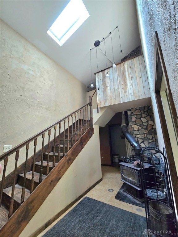 stairs with a wood stove and vaulted ceiling