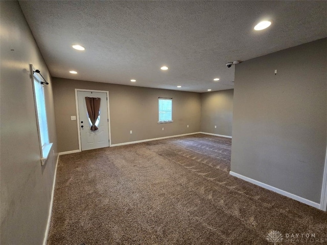 interior space featuring baseboards, recessed lighting, a textured ceiling, and carpet