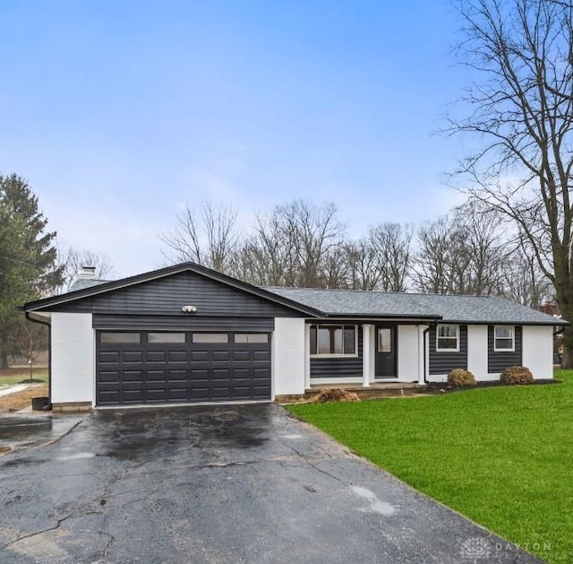 ranch-style home with a garage and a front lawn