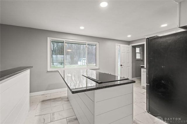 kitchen with white cabinetry, black appliances, and a center island