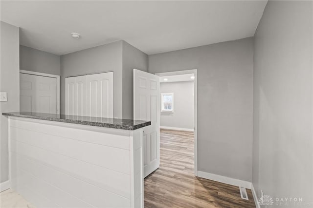 interior space featuring hardwood / wood-style flooring, white cabinetry, and kitchen peninsula