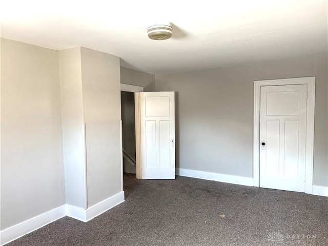 unfurnished bedroom featuring dark carpet