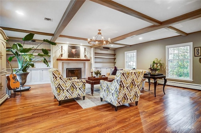 living room with an inviting chandelier, light wood-type flooring, beam ceiling, and a baseboard radiator