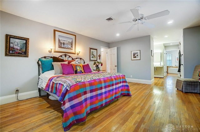 bedroom with light hardwood / wood-style flooring, ceiling fan, and a baseboard radiator