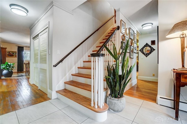 stairway featuring tile patterned floors and a baseboard heating unit