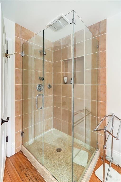 bathroom featuring hardwood / wood-style flooring and walk in shower