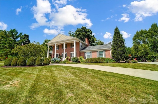 neoclassical home featuring a front lawn