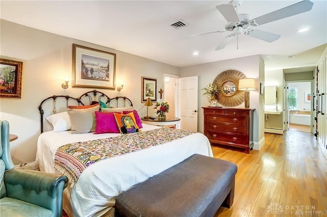 bedroom with light hardwood / wood-style floors, ceiling fan, and a baseboard heating unit