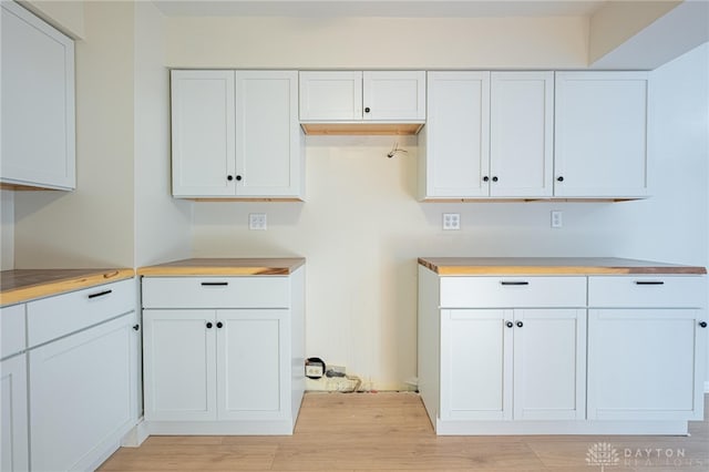 kitchen featuring white cabinetry, butcher block countertops, and light wood-type flooring