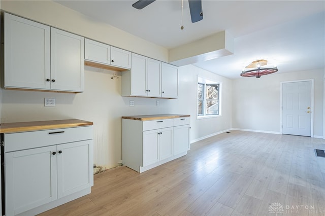 kitchen featuring wooden counters, light hardwood / wood-style flooring, and white cabinets