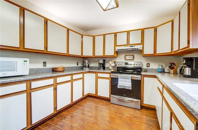 kitchen featuring stainless steel range with electric stovetop and white cabinetry