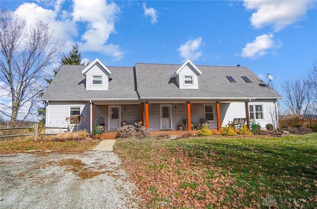 cape cod house with a front lawn and covered porch