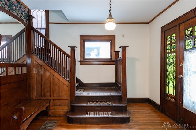 foyer entrance with french doors, ornamental molding, hardwood / wood-style floors, and plenty of natural light