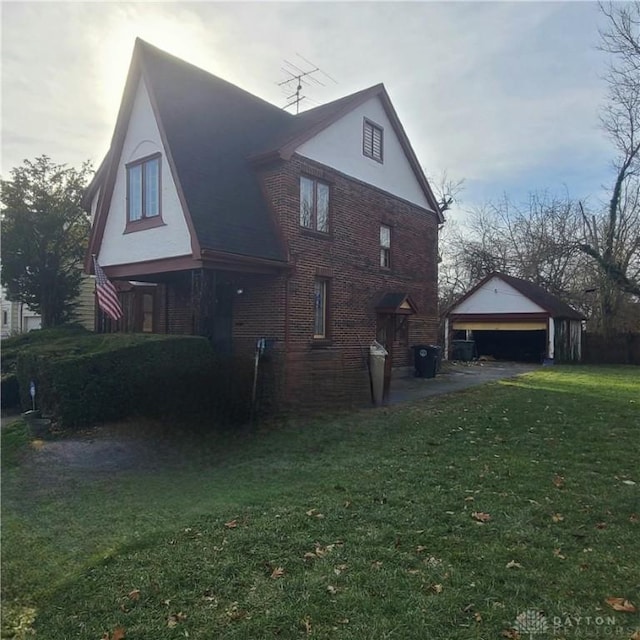 view of side of property with a garage, a yard, and an outdoor structure