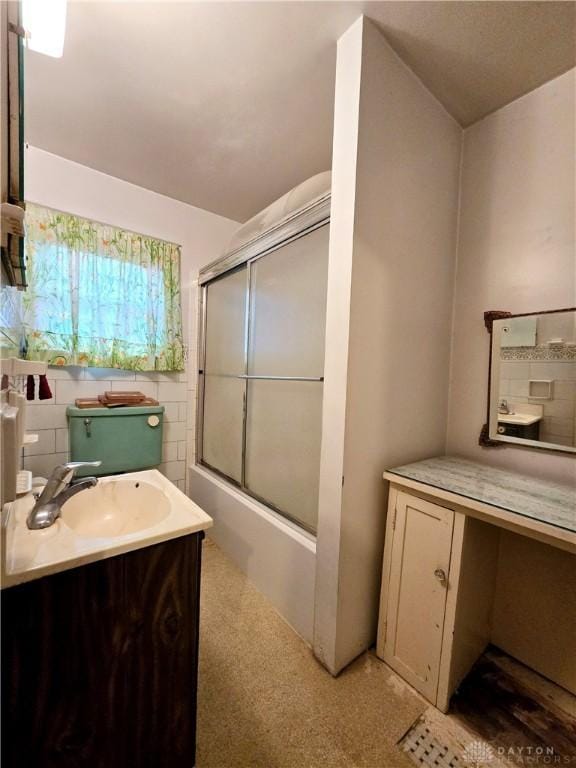 bathroom featuring combined bath / shower with glass door and vanity