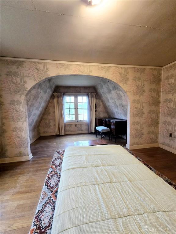 unfurnished bedroom with lofted ceiling and wood-type flooring