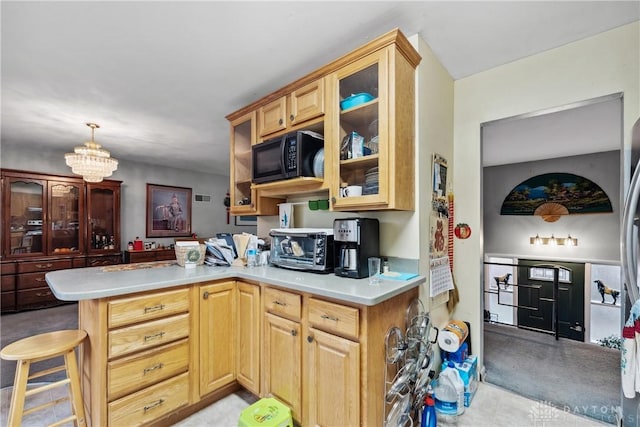 kitchen with a breakfast bar area, light brown cabinetry, a notable chandelier, and kitchen peninsula