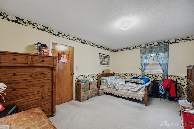 bedroom featuring a textured ceiling and light colored carpet