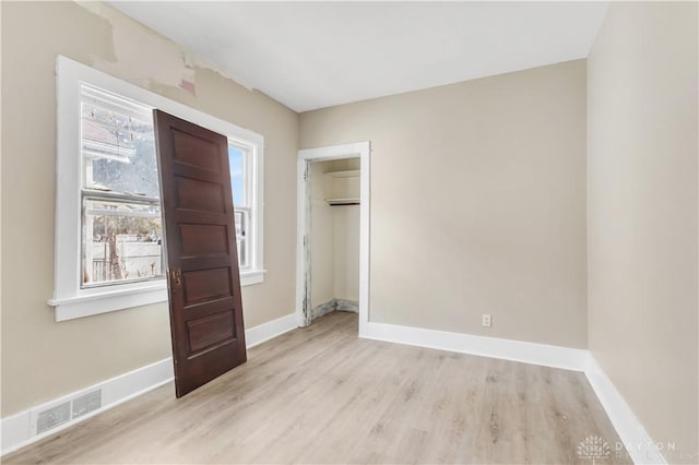 unfurnished bedroom featuring a closet and light hardwood / wood-style floors