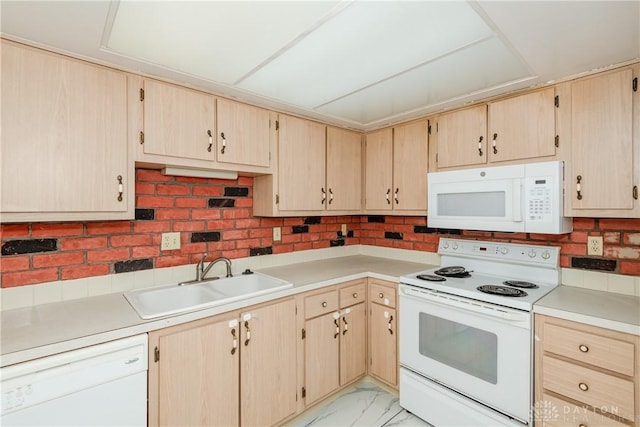 kitchen featuring white appliances, sink, and light brown cabinetry