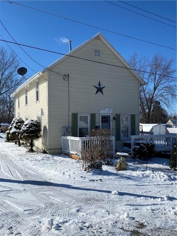 view of snow covered back of property