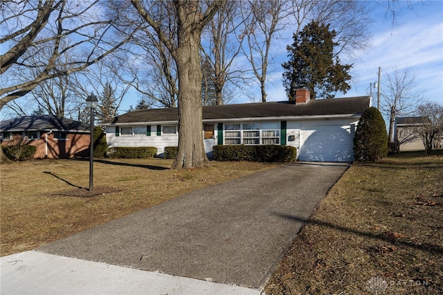 ranch-style home with a garage and a front lawn