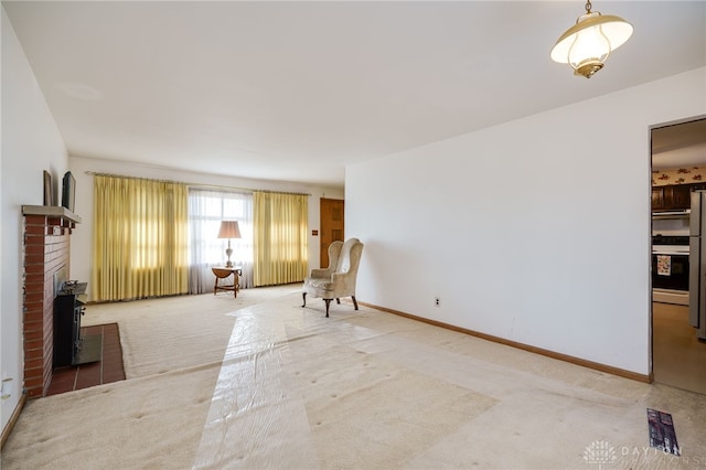 unfurnished room featuring carpet flooring and a brick fireplace