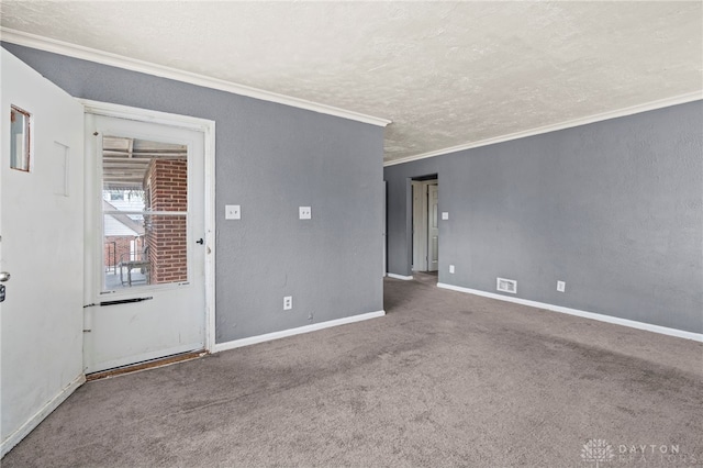 empty room with ornamental molding, carpet, and a textured ceiling