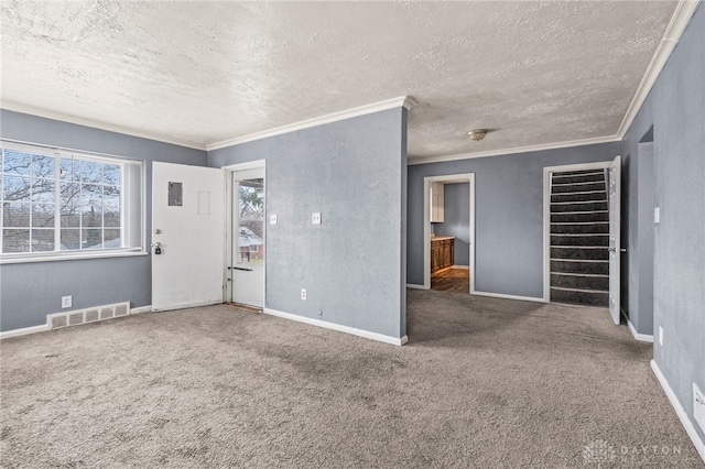 interior space featuring carpet floors, a textured ceiling, and ornamental molding