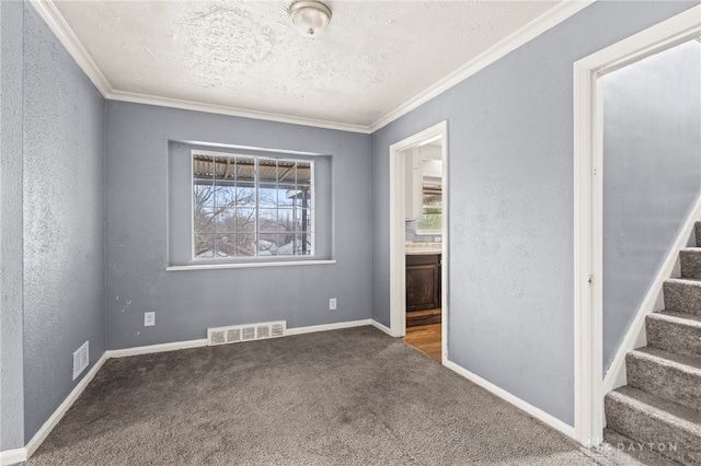 spare room featuring carpet floors, crown molding, and a textured ceiling