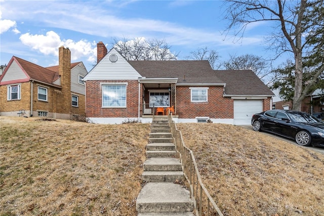 view of front of home featuring a porch, a garage, and a front yard