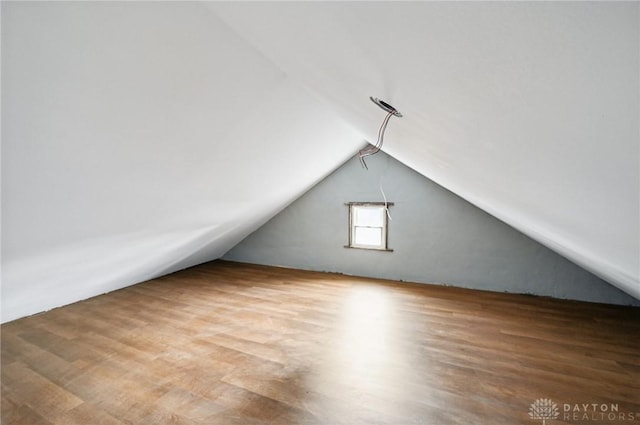 bonus room with lofted ceiling and hardwood / wood-style floors