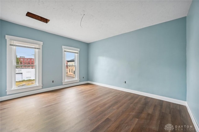 empty room featuring a textured ceiling and wood-type flooring