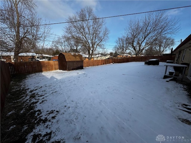 snowy yard featuring a storage unit