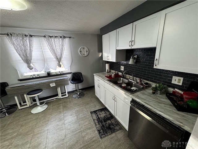 kitchen featuring dishwasher, a textured ceiling, decorative backsplash, sink, and white cabinetry