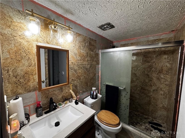 bathroom featuring a shower with shower door, toilet, tile walls, a textured ceiling, and vanity