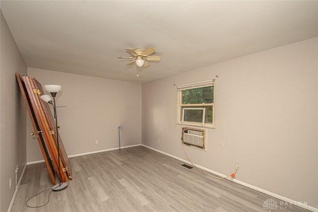 spare room featuring light hardwood / wood-style flooring, ceiling fan, and a wall unit AC