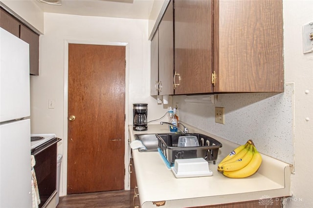 kitchen featuring sink, white appliances, and dark hardwood / wood-style floors