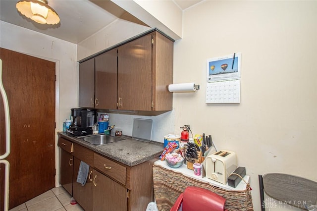 kitchen featuring light tile patterned floors and sink