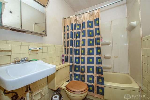 full bathroom featuring sink, toilet, tile walls, and shower / bath combination with curtain