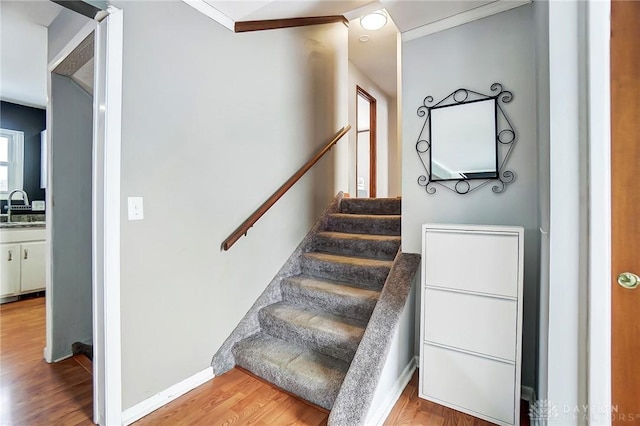 stairway with sink and wood-type flooring