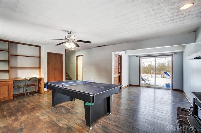 rec room featuring ceiling fan, dark wood-type flooring, a textured ceiling, and built in desk