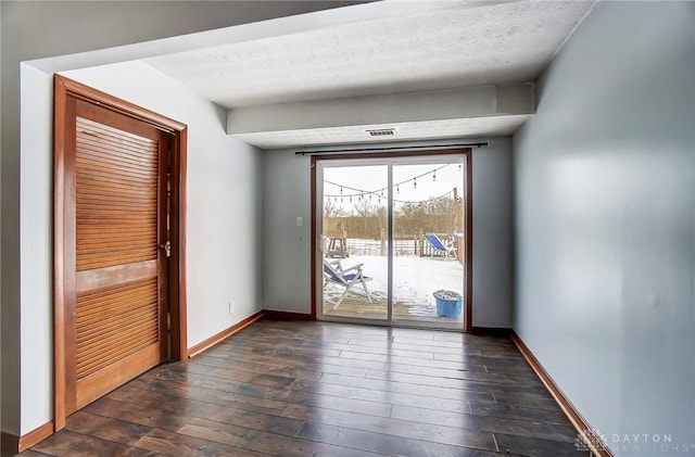 doorway featuring dark hardwood / wood-style flooring and a textured ceiling