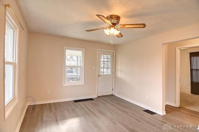 interior space featuring ceiling fan, light hardwood / wood-style flooring, and a textured ceiling