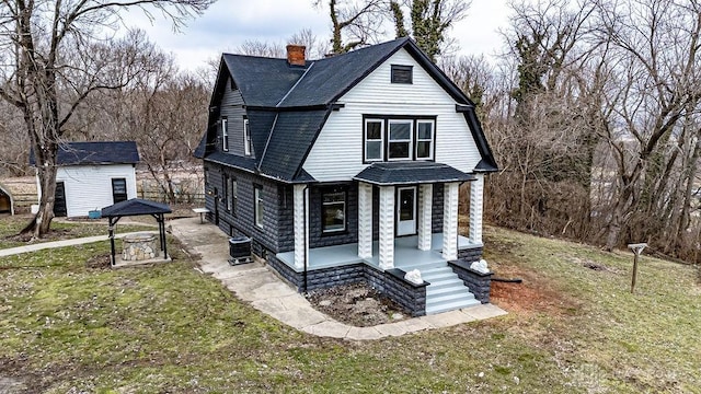 view of front of property with a front yard and central air condition unit