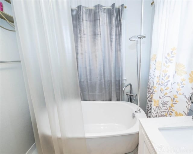 bathroom with vanity and a bath