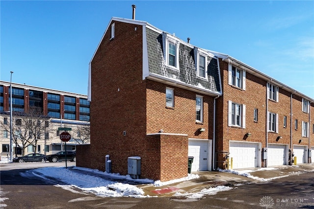 snow covered building with an attached garage