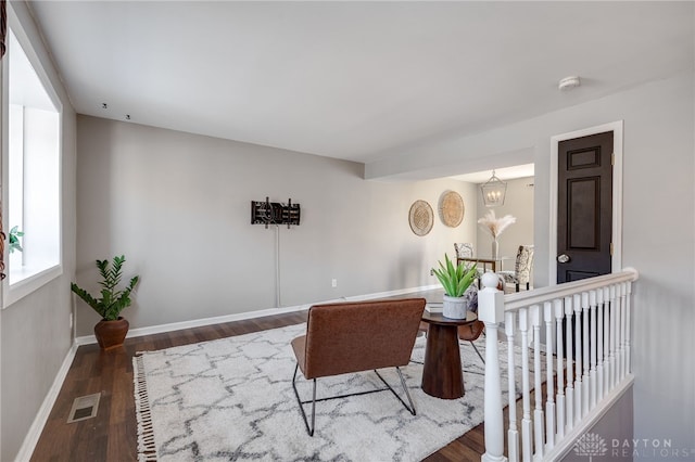 interior space with a chandelier, dark wood-style flooring, an upstairs landing, visible vents, and baseboards