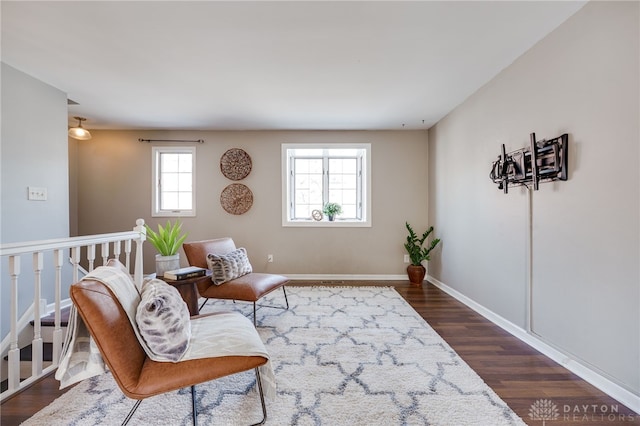 living area with dark wood-style floors, an upstairs landing, and baseboards